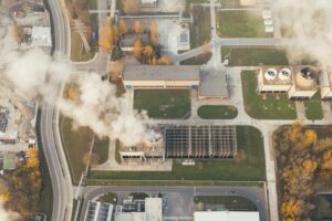 Vue aérienne d'une zone industrielle avec des émissions de fumée visibles.