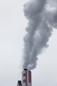 cheminée d'usine rouge avec fumée